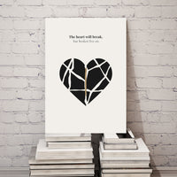 Canvas print with a black heart design and text on a stack of books against a white brick wall.