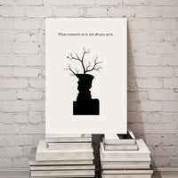 Canvas print with a silhouette of a person and tree branches on a white brick wall.