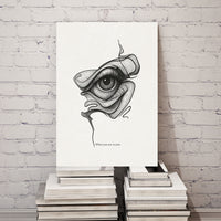 Abstract artwork of an eye on a white canvas against a white brick wall.