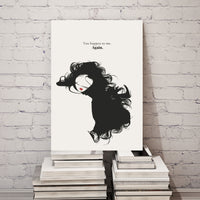 Canvas print with a black and white illustration of a woman's silhouette and text, placed on books against a white brick wall.