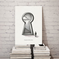Art print with a keyhole and cloud design on a stack of books against a white brick wall.