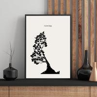 Framed black and white tree print with 'Growing.' text on a wall with wooden paneling.