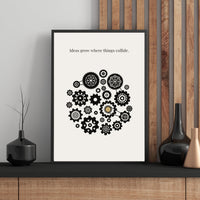 Framed poster with mechanical gear design and text on a wall with wooden paneling.