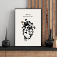 Framed artwork with a black and white illustration of a heart and roses on a white background, placed on a wooden shelf.