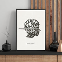 Framed artwork with a puzzle-themed design on a wall with wooden paneling.