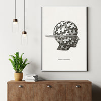 Minimalist black and white poster of a human head made of puzzle pieces with the quote “Identity is assembled”