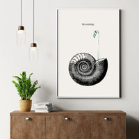 Framed artwork of a black spiral design on a white wall above a wooden cabinet with a plant and books.