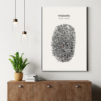 Framed artwork with fingerprint design and text 'Originality leaves a mark' on a wall above a wooden cabinet.
