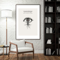 Framed artwork with an eye design and text in a living room setting.
