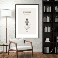 Framed artwork with a pen and inkwell design on a wall in a room with a chair, lamp, and bookshelf.