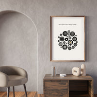 Framed poster with gear design on a wall above a wooden desk.
