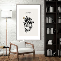 Framed artwork with a quote on a wall in a room with a chair, lamp, and bookshelf.