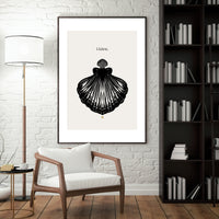 Modern living room with a black and white shell art print, wooden armchair, and bookshelf.