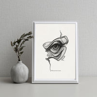 Framed artwork of an eye design on a wall with a vase and plant.