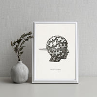 Framed artwork of a head silhouette with puzzle pieces on a neutral background