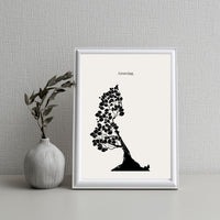 Framed black and white tree illustration with 'Growing.' text next to a vase on a textured wall background