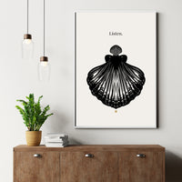 Framed artwork of a black shell with 'Listen' text on a white wall above a wooden cabinet.