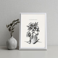 Framed artwork with a hand holding flowers next to a vase on a textured wall background