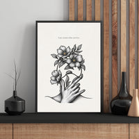 Framed artwork with a hand holding flowers on a wall with wooden paneling.
