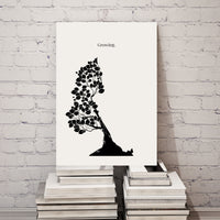 Black and white tree silhouette art print on a white background, leaning against a white brick wall.