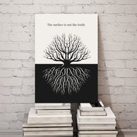 Canvas print with a black and white tree design and text on a stack of books against a white brick wall.