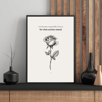 Framed artwork with a rose illustration and text on a wall with wooden paneling.